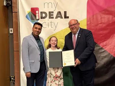 Councillor and mayor posing with youth and certificate