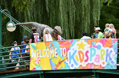KidsPark sign on a bridge with people walking by