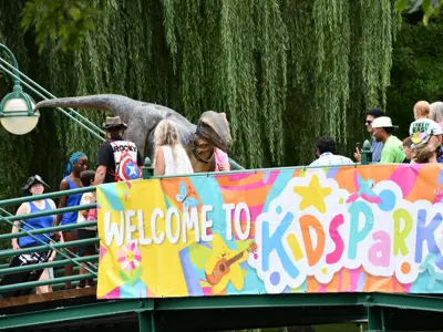 KidsPark sign on a bridge with people walking by