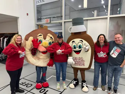 Councillors standing with mascots dressed up as maple syrup
