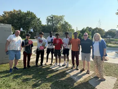 City councillors and mayor posing for photo with youth outside at park