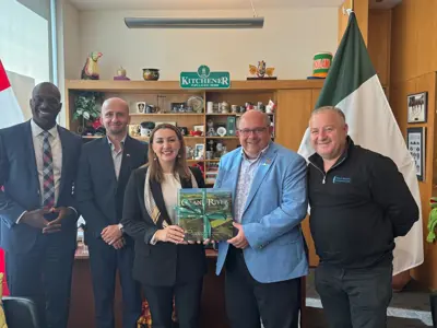 group of adults in office posing for photo with a book