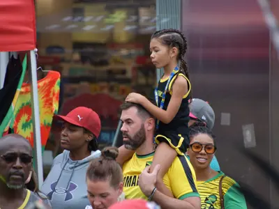 child sitting on man's shoulders at music festival