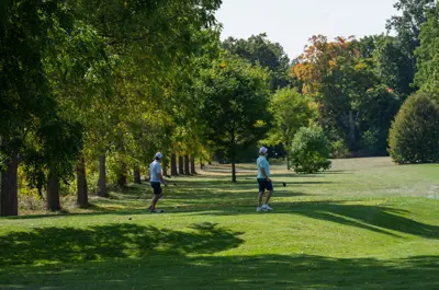 People playing golf and walking towards the green