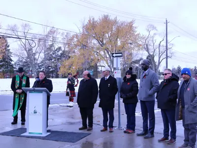 City councillor standing at podium outside for a press conference