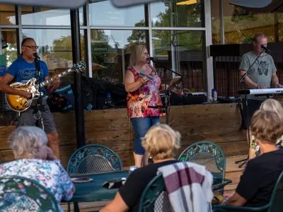 Three individuals performing live music to a crowd