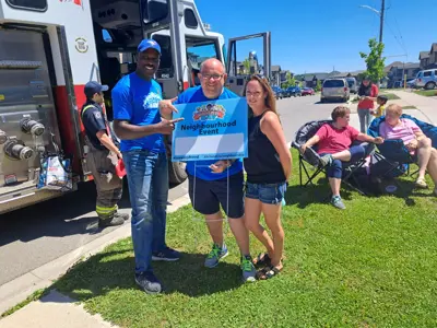 Three adults standing in front of a fire truck