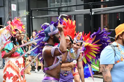 Revellers in colourful costumes walking down King Street