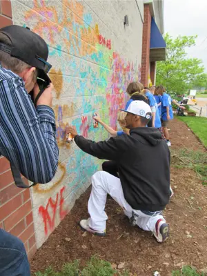 Volunteers working on artwork on a wall