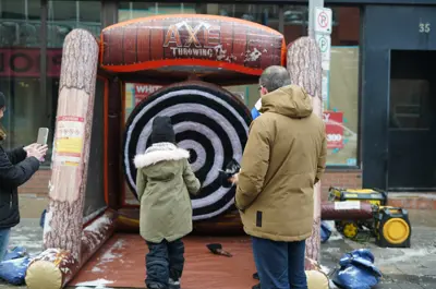 kid and father playing inflatable axe throwing