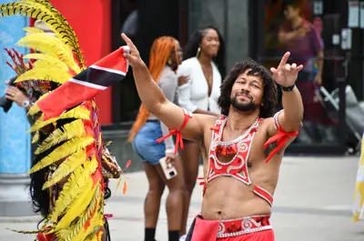 Revellers in colourful costumes walking down King Street