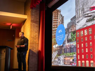 A man standing on a stage delivering a presentation