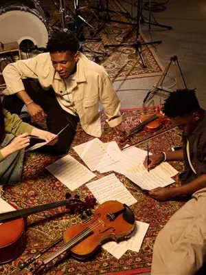 People discussing music while sitting with their instruments