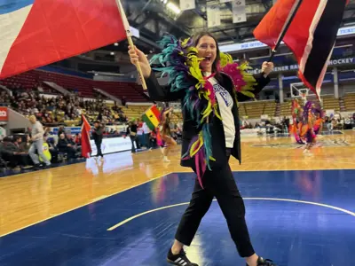 Councillor on on basketball court holding flags